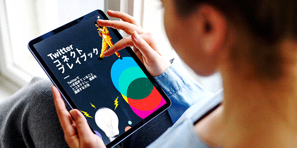 女性が手に持ったiPadを使用してTwitterコネクトプレイブックを読む様子を肩越しに捉えた場面